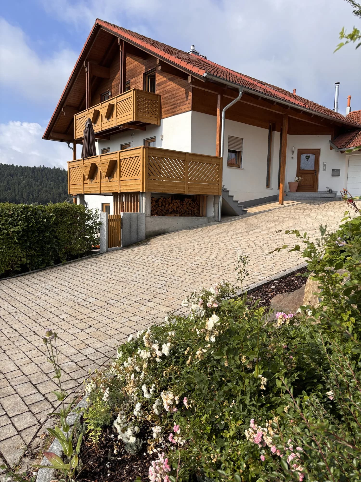 Vorderansicht des Hauses mit gepflasterter Zufahrt und geräumiger Doppelgarage