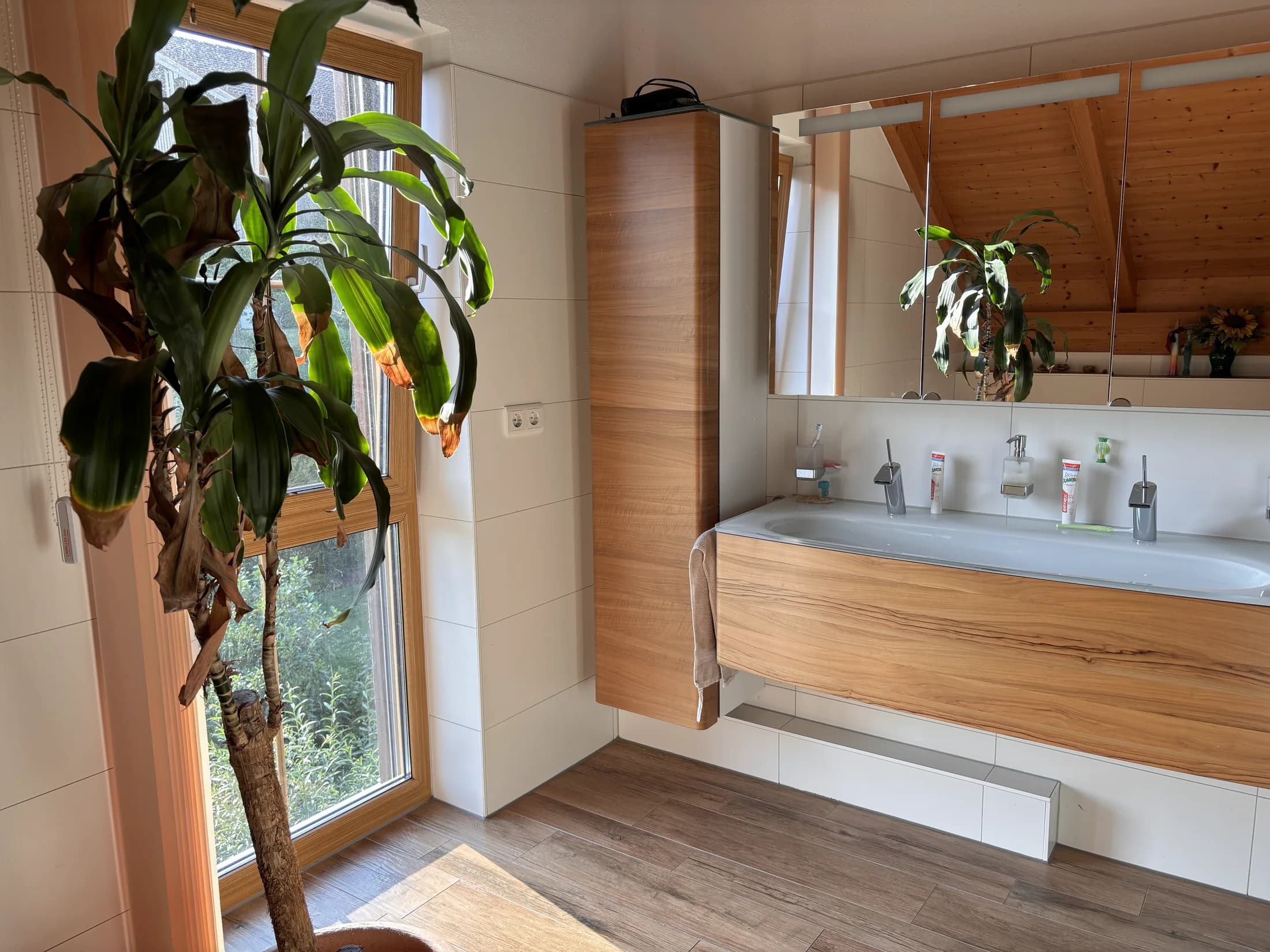 Bad mit Badewanne, Holzoberflächen und großem Fenster