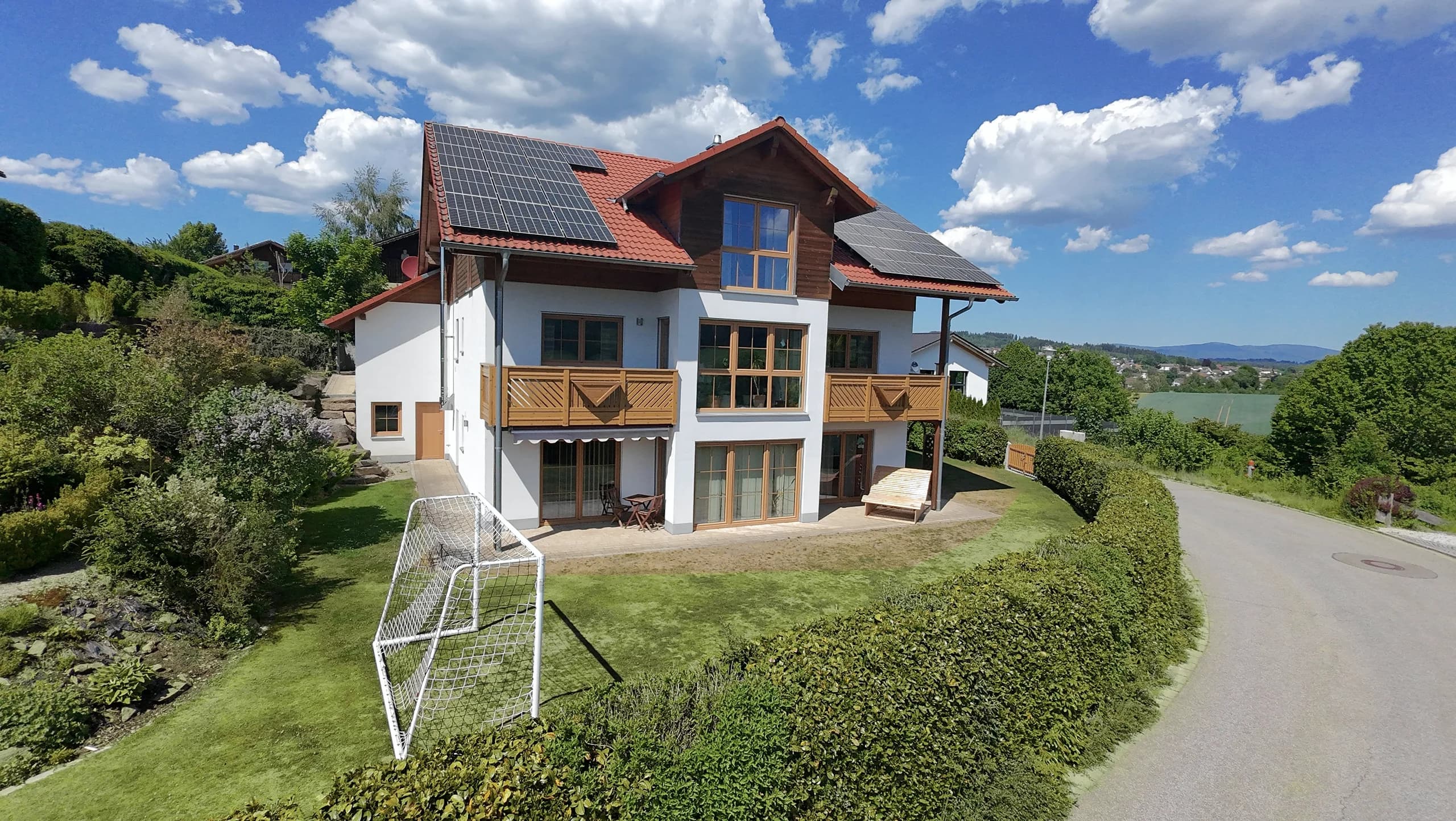 Außenansicht des Hanghauses mit Photovoltaikanlage und Blick über Regen
