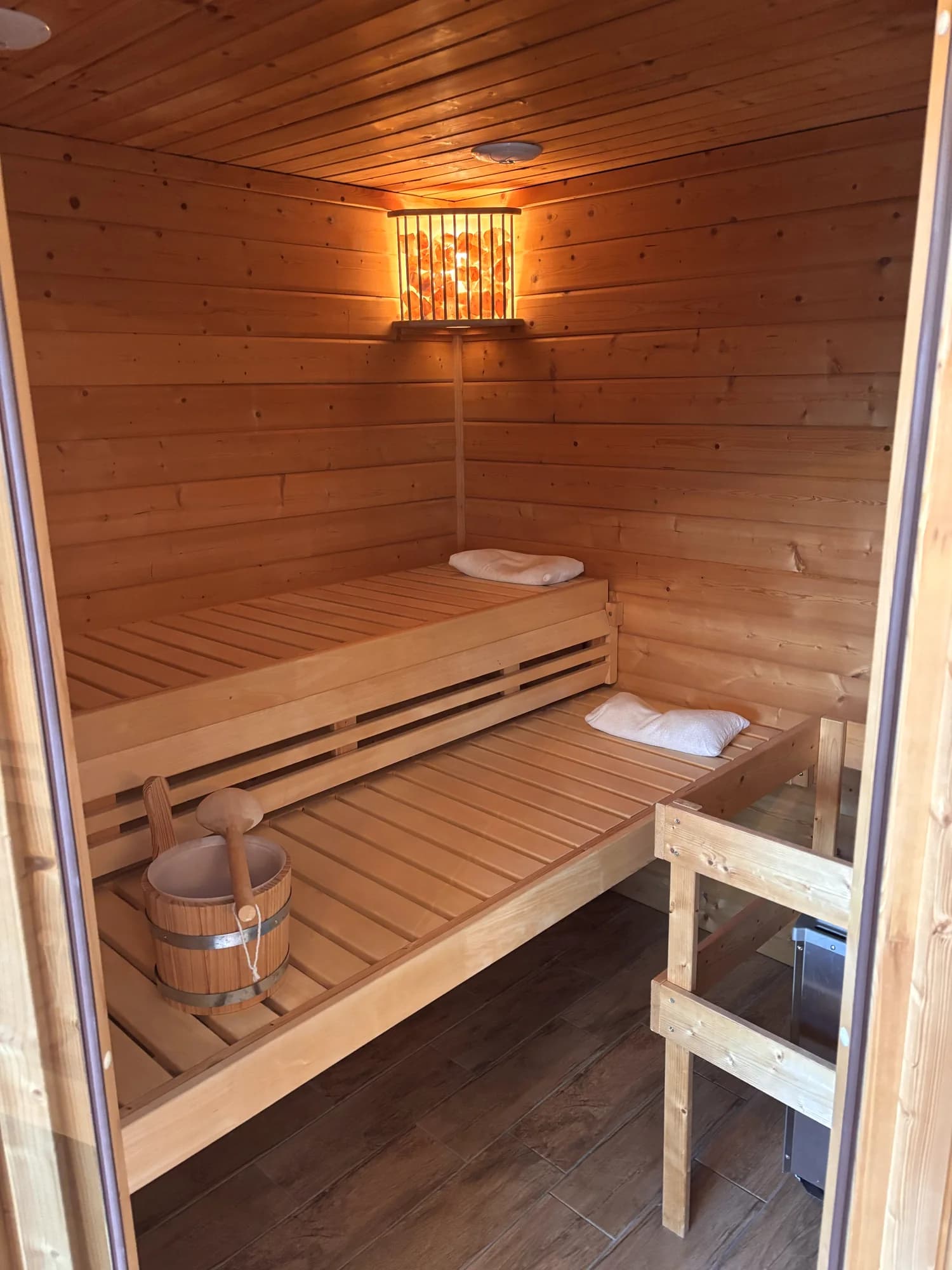 Holzsauna mit Sitzbänken und warmer Beleuchtung