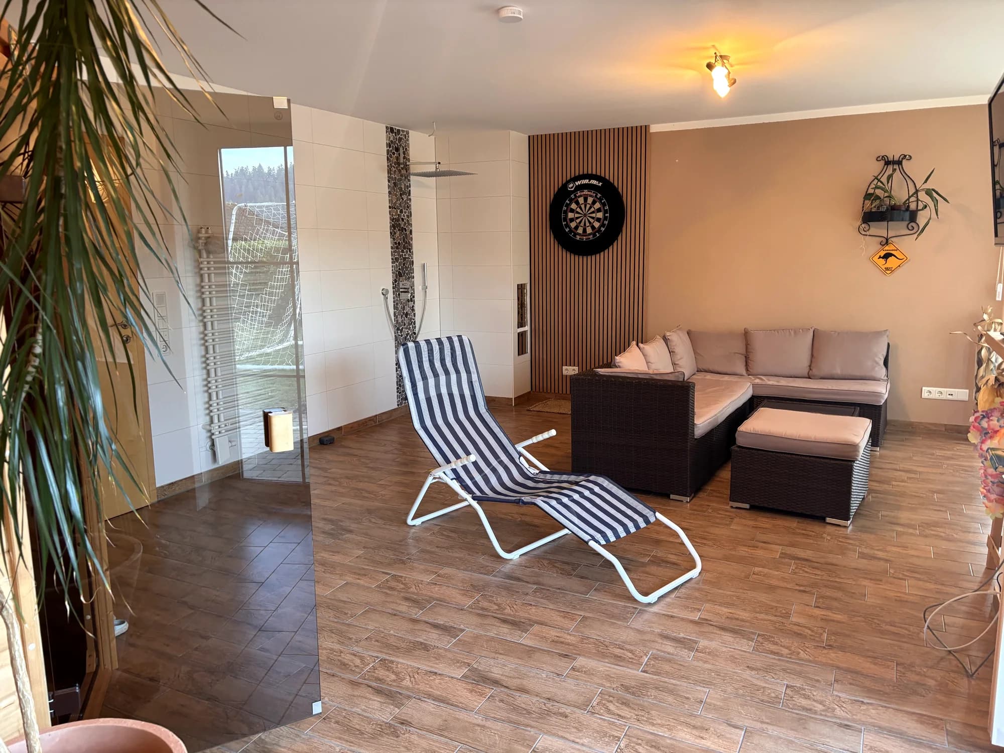 Ruhebereich des Wellnessbereichs mit Loungeliege und Dusche